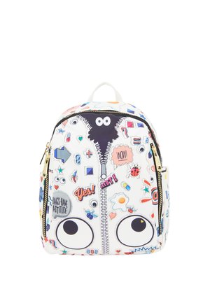 Backpack decorated with large cartoon eyes, colorful patches, playful symbols, and text like "Yes!" and "Bags have attitude" on white background.