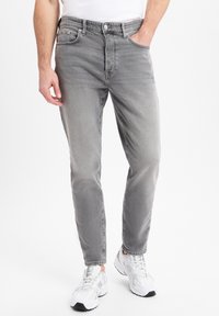 Jeans de denim gris con corte recto, que cuentan con un diseño de cinco bolsillos, cierre de botón y un ligero desvanecimiento en toda la tela.