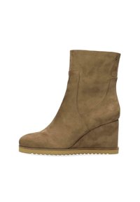 Brown suede wedge ankle boot featuring a rounded toe, elastic side panels, and a textured rubber sole with zigzag design along the edge.