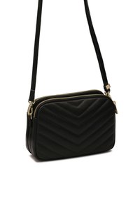 Borsa a tracolla in pelle nera con un motivo a zigzag trapuntato, hardware dorato e chiusura con doppia cerniera. Presenta una tracolla sottile e regolabile.