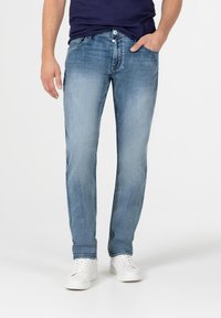 Lichtblauwe denim jeans met een rechte pijp, voorzien van een klassieke vijf-pocketontwerp en subtiele vervaging op de bovenbenen. Gecombineerd met witte sneakers.