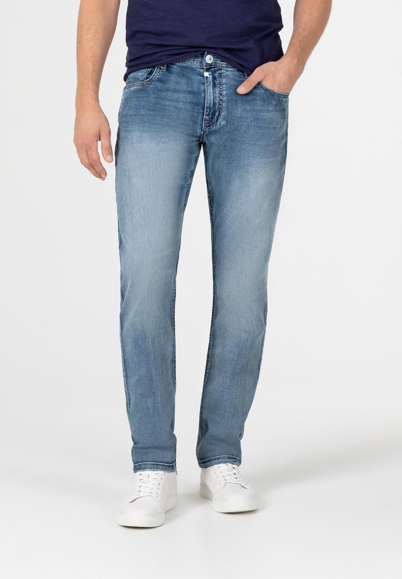 Lichtblauwe denim jeans met een rechte pijp, voorzien van een klassieke vijf-pocketontwerp en subtiele vervaging op de bovenbenen. Gecombineerd met witte sneakers.