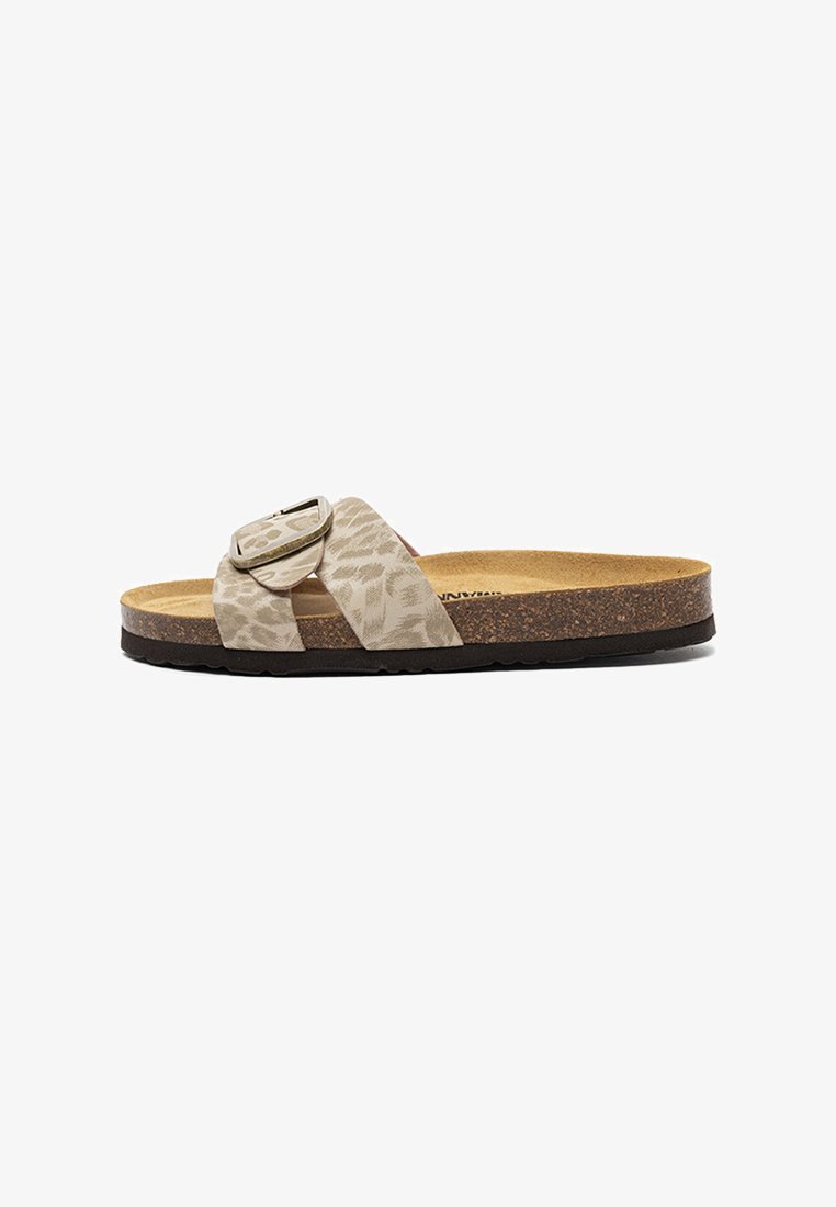 Slide sandal with a cork footbed, black sole, beige animal-print strap, and a large adjustable buckle on the top.