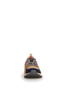 Zapatilla multicolor con parte superior en azul marino y marrón, suela de goma texturizada y cordones estampados. Presenta una tira de agarre en la parte trasera.