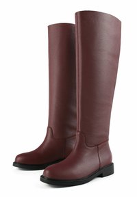Long burgundy leather boots with a textured finish, rounded toe, and black rubber sole. Ankle height with a seamless upper shaft design.