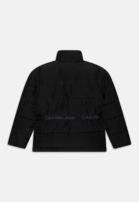 Giacca piumino nera con motivo a righe orizzontali, collo alto e fascia con logo in vita. Realizzata in un materiale liscio e leggero.