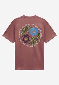 Camiseta marrón con gráficos florales coloridos y texto en la parte posterior. Hecha de una tela suave con un corte relajado y mangas cortas.