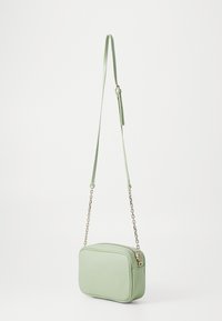 Piccola borsa a tracolla rettangolare in ecopelle verde chiaro, con chiusura a zip e tracolla accentata da catena. Texture liscia.