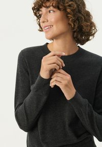 Mørkegrå sweater lavet af blødt materiale med rund halsudskæring, ribbede ærmeender og en afslappet pasform, der har en glat tekstur.