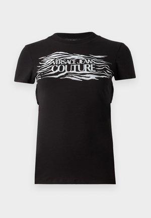 Camiseta de algodón negra con un gráfico texturizado en plata que dice "VERSACE JEANS COUTURE" y patrones de líneas onduladas en el pecho y mangas cortas.