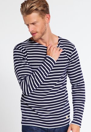 Marineblå og hvidstribet langærmet skjorte med rund halsudskæring og slim fit. Har en lille logo-detalje i sømmen. Blødt bomuldsstof.