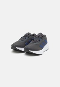 Grey athletic shoes with blue accents, mesh upper, lace-up design, thick white midsole, and textured black outsole. Suitable for sports.