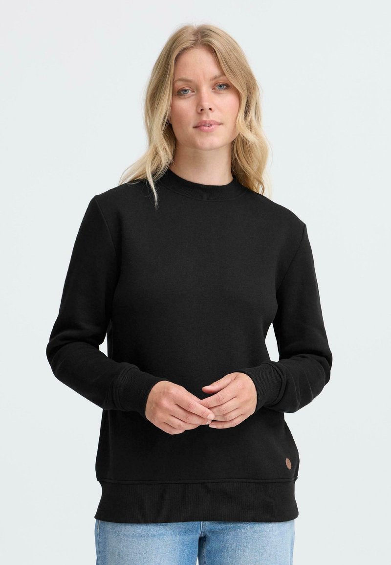 Sweatshirt en coton noir avec un col rond, des poignets et un ourlet côtelés. Présente un petit logo marron sur le bas à gauche. Design uni.