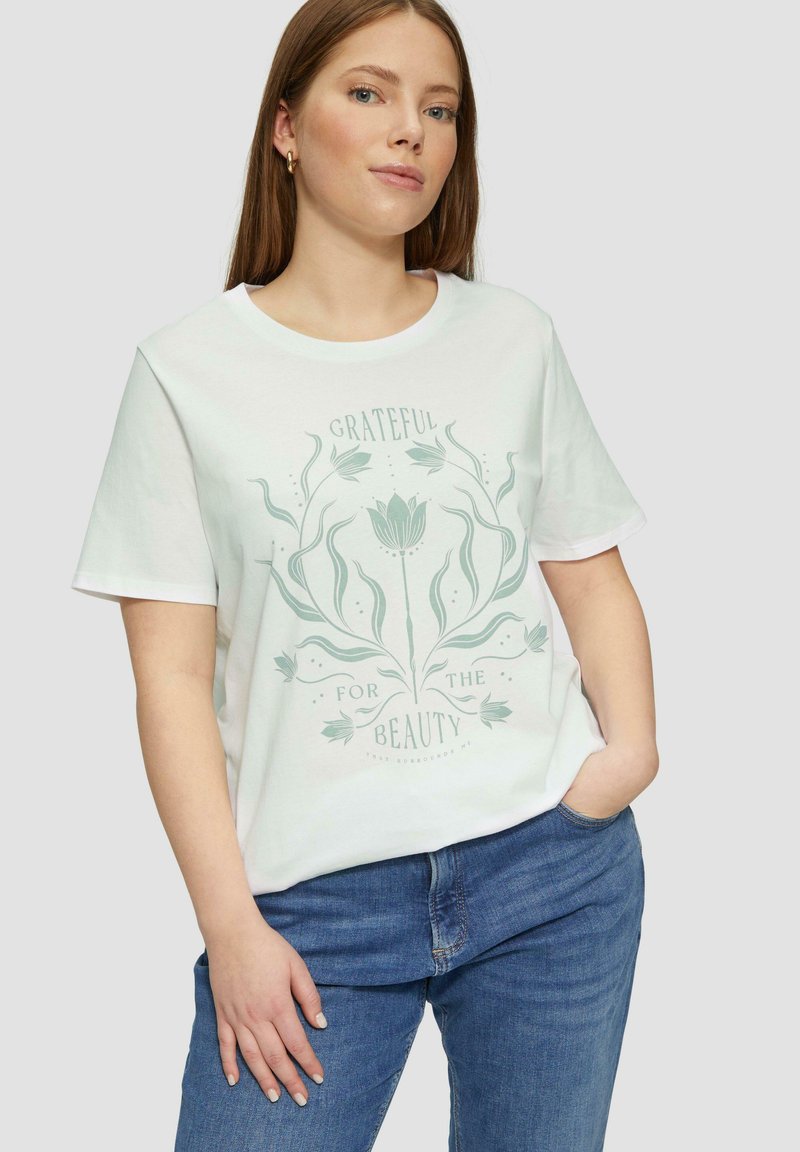Witte katoenen T-shirt met een groene bloemenafbeelding en de tekst "BLIJ MET DE SCHONE DINGEN". Korte mouwen en een relaxed fit.