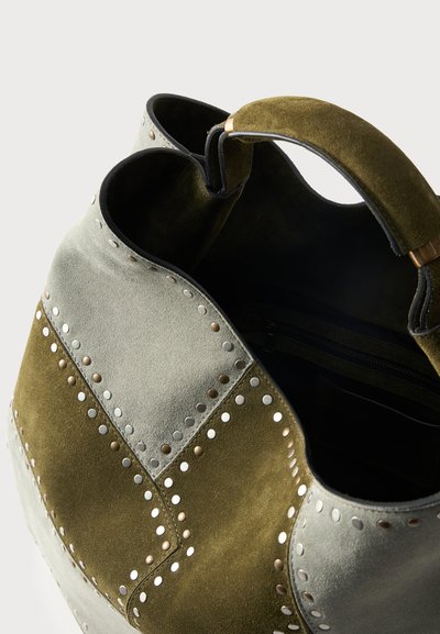 Τσάντα ώμου από σουέντ με ελιά και ανοιχτογκρίζα πάνελ, διακοσμημένη με στρογγυλά μεταλλικά καρφιά και μαλακή λαβή ελιάς, ανοιχτό πάνω μέρος που δείχνει εσωτερική θήκη με φερμουάρ.