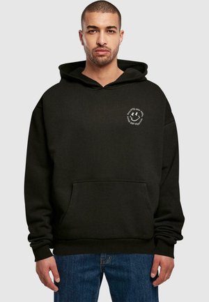 Schwarzer Hoodie mit einer Vorderasche, Kapuze mit Kordelzug und einem runden weißen Logo auf der linken Brust. Mit gerippten Bündchen und Saum.