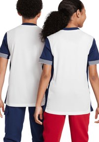 Kurzarm-Sporthemden in Weiß mit marineblauen Akzenten. Seitenteile sind einfarbig navy. Gestreifte Details an den Ärmeln. Glatte Stofftextur.