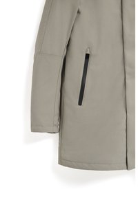 Abrigo gris claro con corte recto, que presenta un bolsillo con cremallera negra en el lateral y una textura suave y mate. Diseño de manga larga.