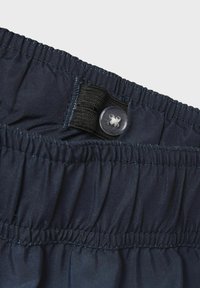 Navy plave hlače s elastikom u struku, s kopčanjem na gumb i naboranom teksturom oko struka, izrađene od lagane tkanine.
