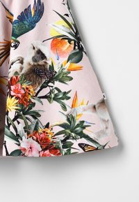 Hedvábí s květinovým vzorem v růžové barvě, obsahující tropické ptáky, opici a motýly, s živými květinami a zelenými listy po celém povrchu.