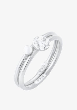Zilveren ring met twee verstrengelde banden, waarvan er één een glad, rond schijfje heeft en de ander een geëxtraheerd rond accent. Gemarkeerd met "925."