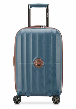 Hard-shell suitcase in blue with a textured finish, brown accents, an extendable handle, and four wheels for mobility.