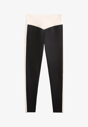 Svart och cream leggings med hög midja, prydda med en diagonalt cream detalj framtill och tillverkade av ett mjukt, stretchigt material.