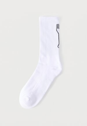 Weißer gerippter Sportsocken mit schwarzem abstraktem Linienmuster entlang der Außenseite, flach auf hellem Hintergrund liegend.