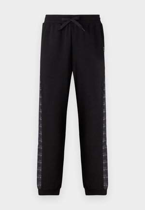 Pantaloni sportivi neri con vita regolabile, caratterizzati da strisce laterali testurizzate che mostrano modelli di testo ripetuti. I polsini completano il design.