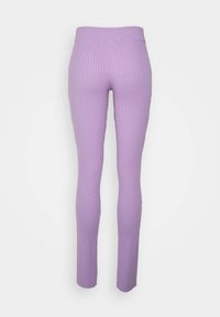 Leggings lilás canelados com um design ajustado, apresentando uma cintura elástica e pernas afuniladas, feitos de um tecido suave e texturizado.