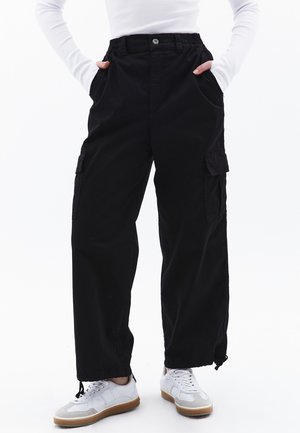 Black cargo pants featuring a straight-leg design, elastic waistband, side pockets, and drawstring hems for adjustability.