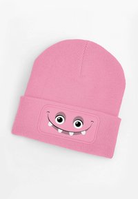 Pink knit beanie with a folded cuff, featuring a smiling monster face graphic with large eyes and white teeth. Soft texture and stretchy fit.