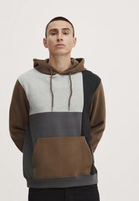 Hoodie met een kleurenblokontwerp in grijs, bruin en zwart. Voorzien van een voorzak en een capuchon met trekkoord en metalen punten.