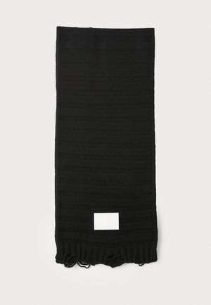 Écharpe noire avec un motif rayé texturé, finie par des franges aux extrémités, avec une petite étiquette blanche. Matériau en tricot léger.