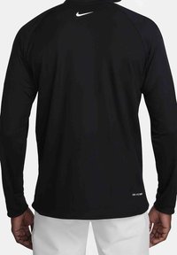 Maglietta sportiva nera a maniche lunghe con colletto girocollo, realizzata in tessuto leggero, caratterizzata da un piccolo logo Nike bianco sulla parte superiore della schiena e un orlo dritto.