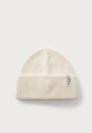 Cream knit beanie with a ribbed texture, folded hem, and a small white fabric label with black text.