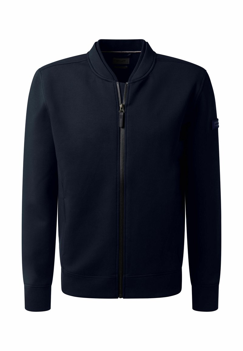 Marineblaue Zip-Jacke aus glattem Stoff. Sie verfügt über einen gerippten Kragen, Bündchen und Saum, mit einem dezenten Logo auf dem Ärmel.