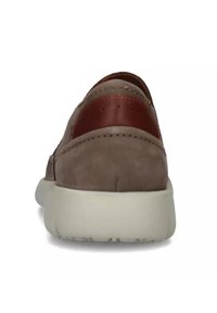 Scarpa in suede marrone con un contrasti accentuato in pelle bordeaux sul tallone e una spessa suola bianca, caratterizzata da dettagli di cucitura sulla parte superiore.