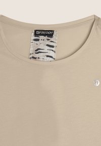 T-shirt beige a maniche corte con scollo rotondo, caratterizzato da un'etichetta di tessuto a righe e un piccolo logo argento sulla parte anteriore. Texture morbida e liscia.