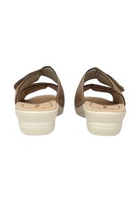 Scarpe di tipo sandalo marroni con retro aperto, dotate di cinturini regolabili e suola interna imbottita, su una suola in gomma bianca testurizzata.