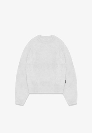 Weißer, flauschiger Pullover mit rundem Halsausschnitt, langen Ärmeln und geripptem Saum. Verfügt über ein kleines Logo auf der Vorderseite, nahe der unteren linken Ecke.