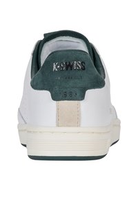 Pantofii de tenis K-Swiss alba cu tab cu suede verde la călcâi, accent din piele bej și detalii perforate pe lateral. Talpa exterioară din cauciuc texturat.
