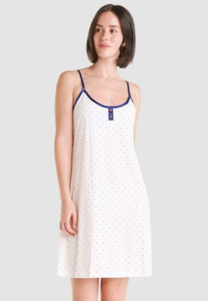 Vestido de dormir de algodón con tirantes finos, de tela blanca, con lunares rojos y azules, y cuello redondo con un detalle de dos botones.