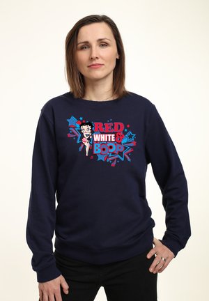 Mørkeblå sweatshirt med et grafisk design, der har rød og blå tekst, der siger "RED WHITE & BOOP", samt en tegneseriefigur i et stribet outfit.