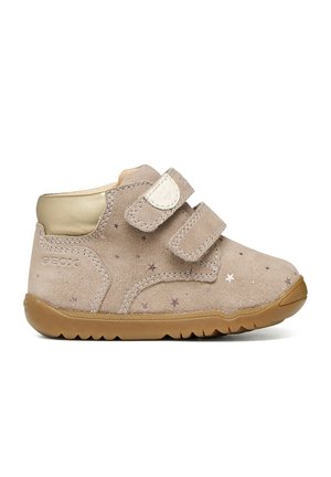 Scarpa da neonato in camoscio beige con due strisce in velcro, motivo a stelle, imbottitura dorata alla caviglia e suola in gomma marrone, vista laterale.
