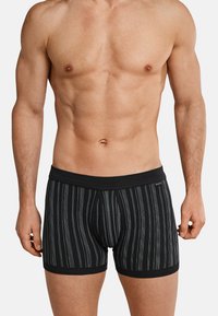 Boxer briefs a strisce nere con una morbida vita; presentano strisce bianche verticali e un design semplice, realizzati in materiale di cotone elasticizzato.