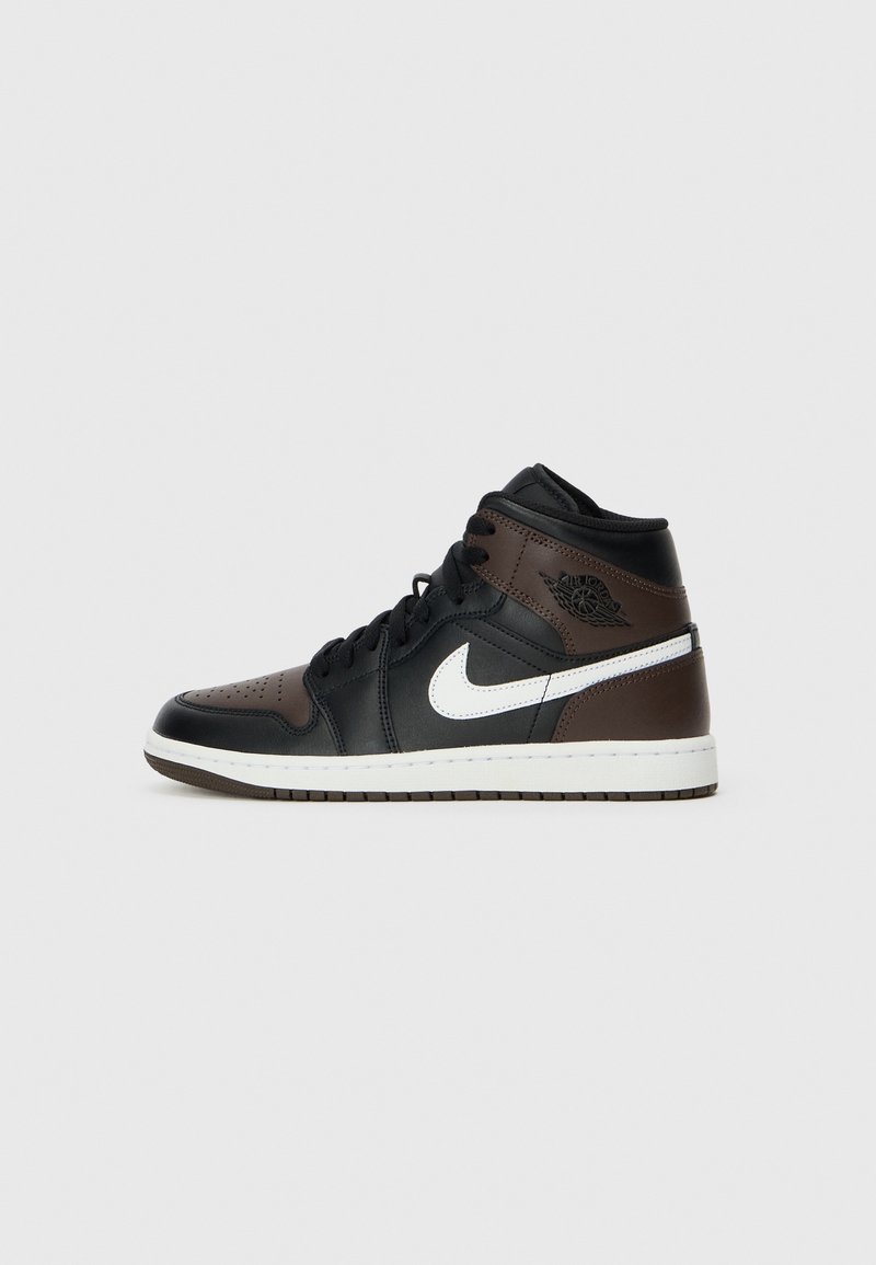 Baskets montantes en cuir noir et marron avec le logo Nike blanc, lacets noirs et semelle blanche, orientées vers la gauche sur un fond clair.