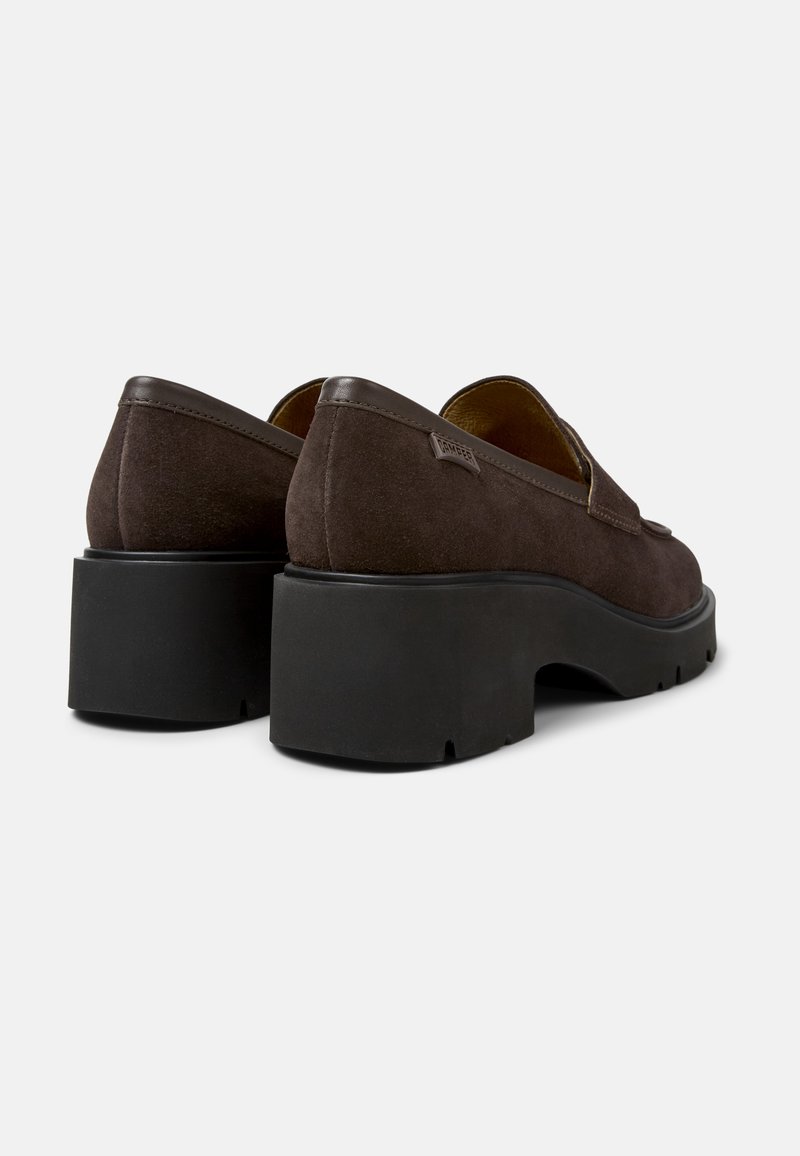 Brązowe zamszowe buty na obcasie z masywną czarną gumową podeszwą. Okrągły czubek i minimalistyczny design, z małą metką z boku.