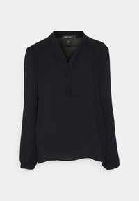 Blouse noire à manches longues avec un décolleté en V et un tissu doux. Présente un détail de couture subtil au niveau du décolleté et des poignets froncés.