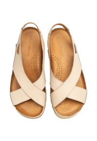 Beżowe skórzane sandały z krzyżującymi się paskami, otwartym tyłem i teksturowaną brązową wkładką, z małymi perforacjami zapewniającymi wentylację.